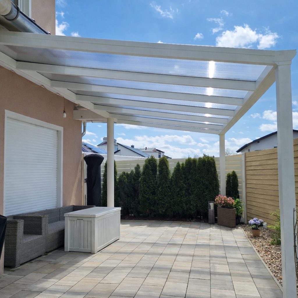 Weiße Terrassenüberdachung aus Aluminium mit Polycarbonatdach an einem Einfamilienhaus in Leipzig