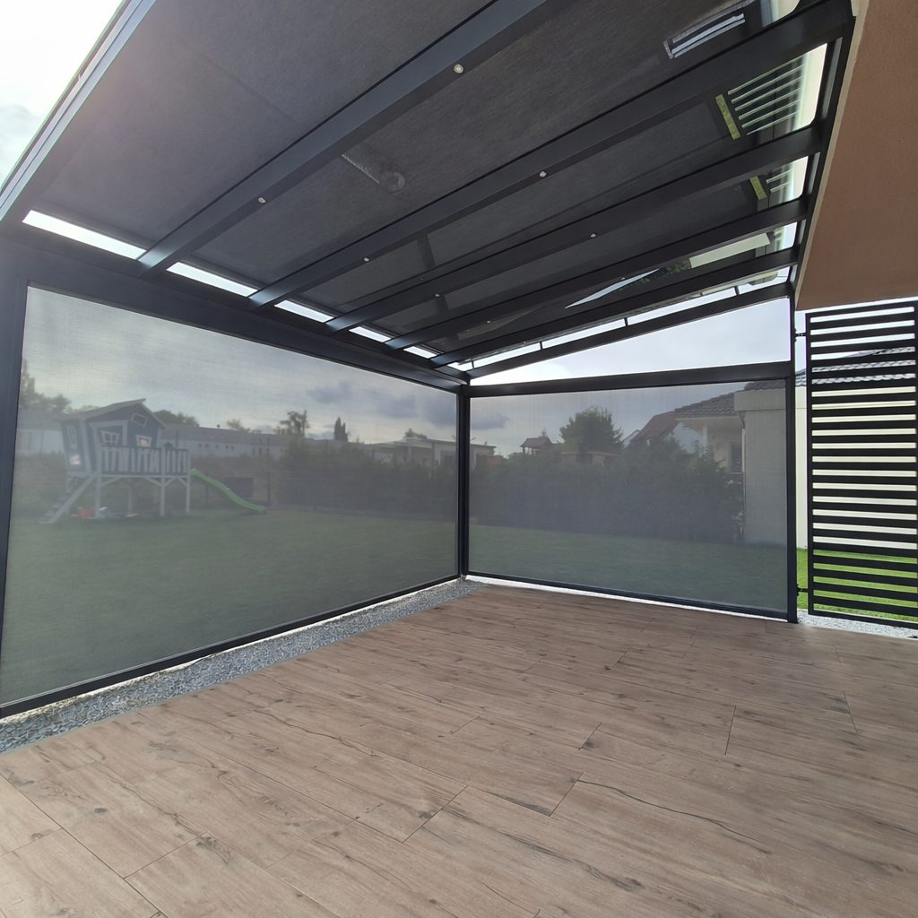 Moderne Pergola in Anthrazit mit seitlichen Screens als Sicht- und Sonnenschutz, Blick aus dem überdachten Terrassenbereich in der Region Leipzig