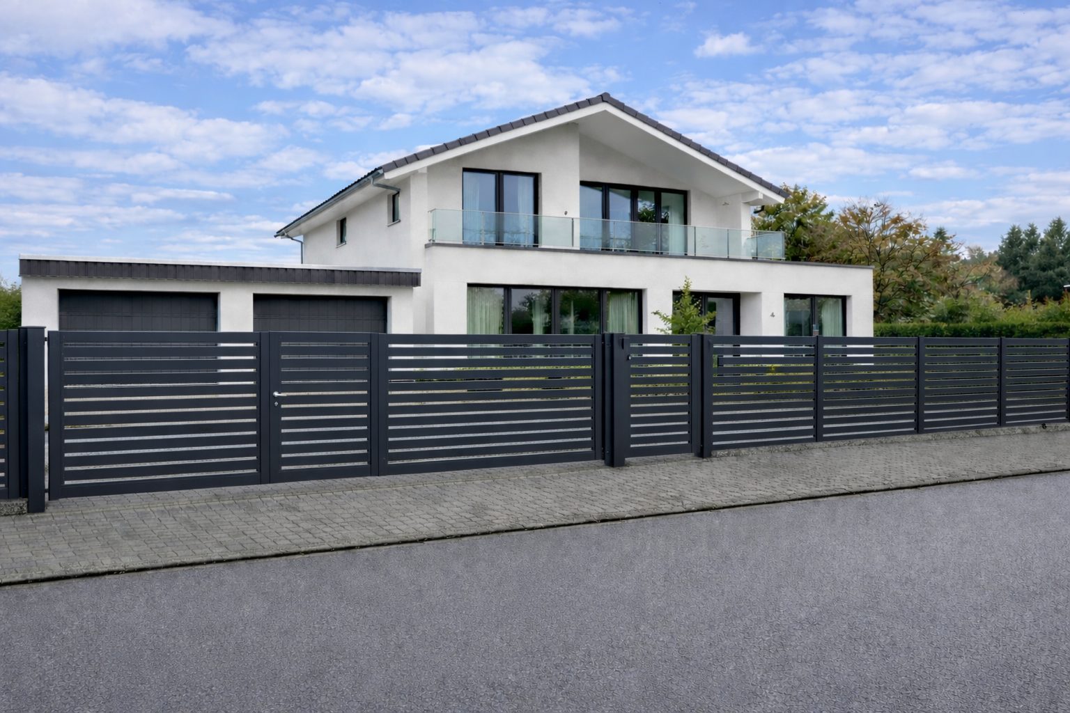 Moderner Aluminiumzaun mit waagerechten Paneelen in Anthrazit vor einem Einfamilienhaus